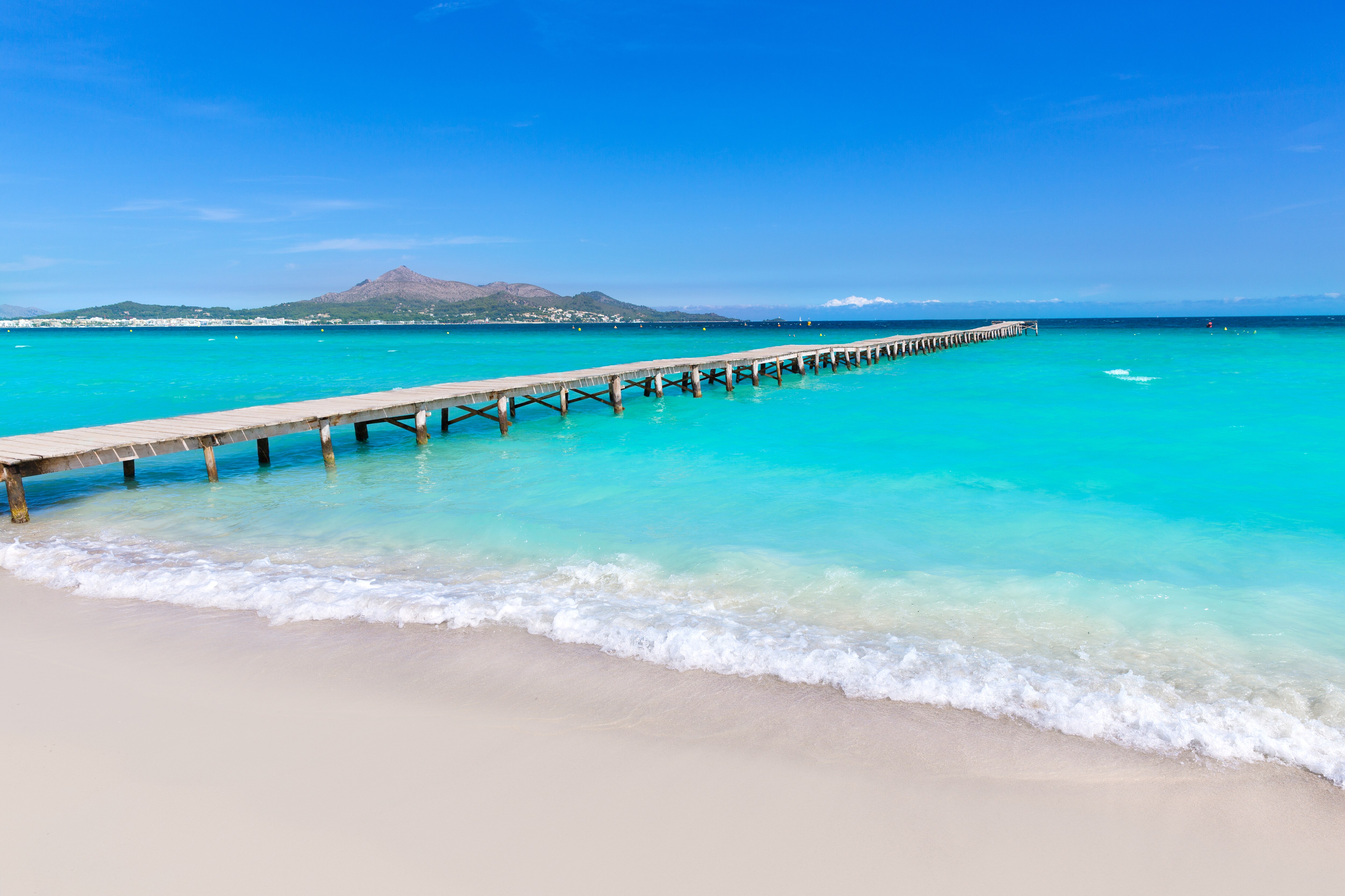 Long Wooden Pier Extending Over Turquoise Sea